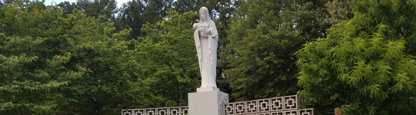 mary statue holding baby in garden