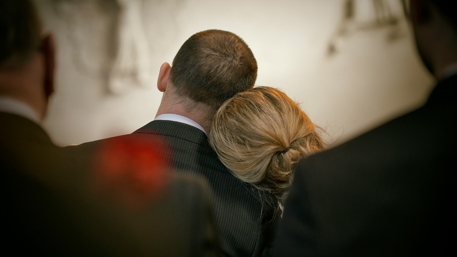 two people leaning on each other at a funeral