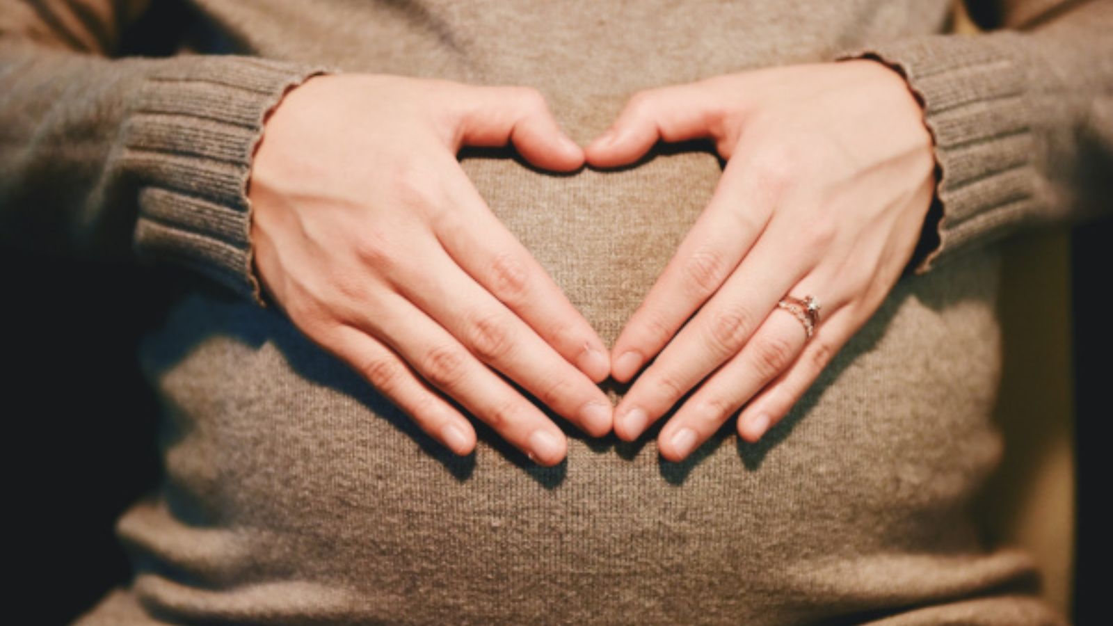pregnant woman with hands over belly